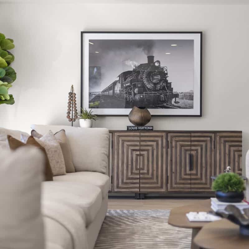 Stylish living room featuring vintage train artwork, contemporary furniture, and elegant decor.