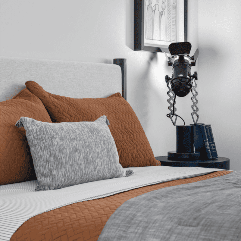 Stylish bedroom with camera-themed decor and cozy bedding.